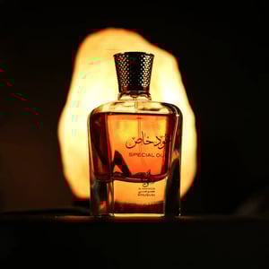 Perfume bottle with a warm glow on a dark background