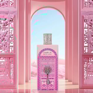 Pink perfume bottle with decorative cap in front of a pink archway
