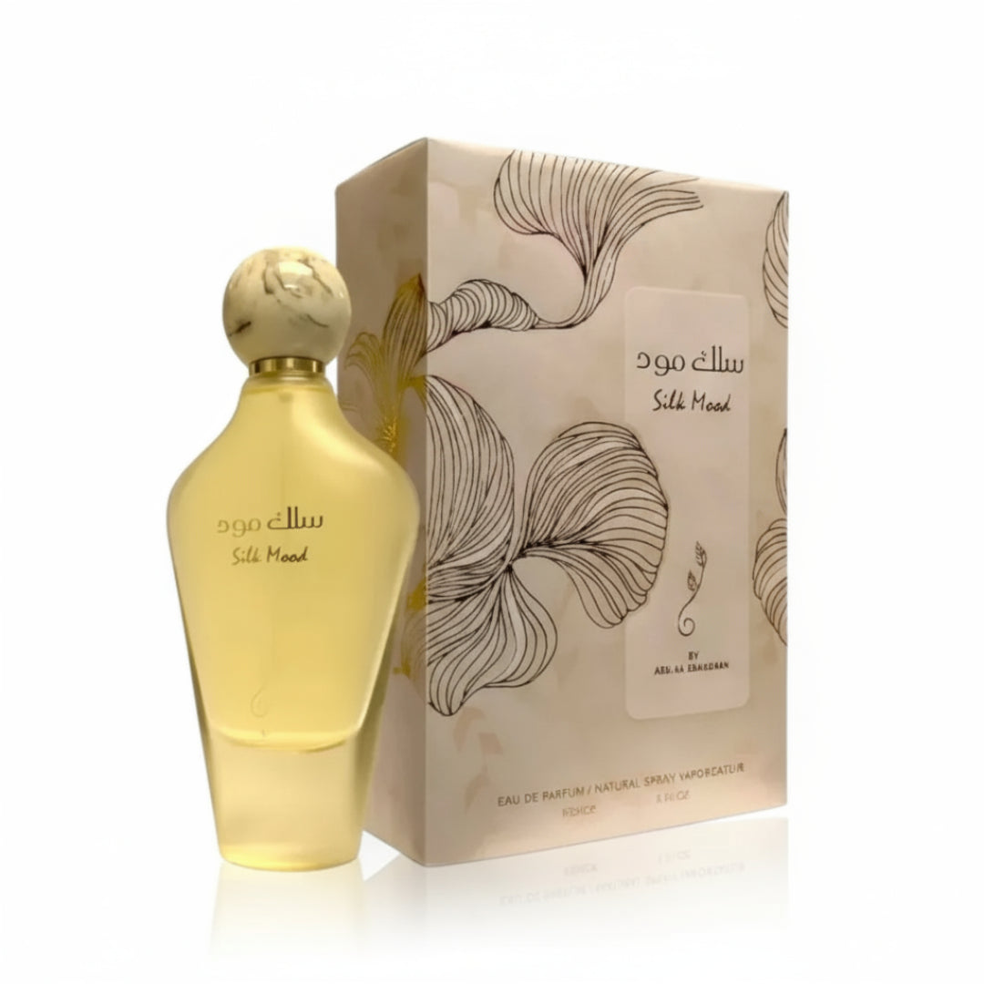Gold perfume bottle and packaging with floral design on a white background