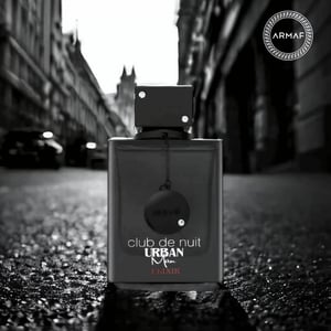 Perfume bottle labeled 'club de nuit Urban Man' by Armaf on a city street.