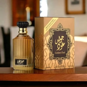 Perfume bottle and packaging of Golden Oud on a wooden surface with a blurred background