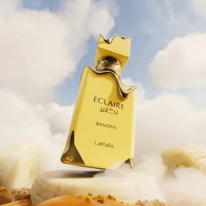 Gold perfume bottle labeled 'Eclaire' with clouds and sand in the background