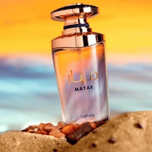 Perfume bottle labeled 'MAYAR' by Lattafa on a beach with sunset background