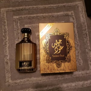 Perfume bottle and packaging on a textured surface