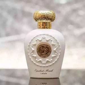 Opulent Perfume bottle with gold cap and intricate design on a blurred background