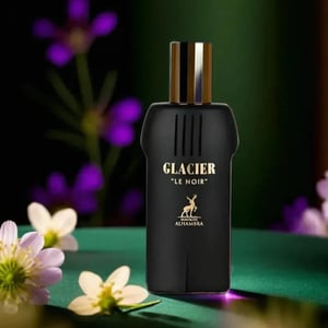 Black perfume bottle labeled 'Glacier Le Noir' with flowers in the background