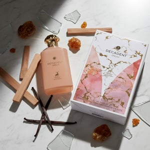 Decadent Dream perfume bottle and packaging on a patterned fabric background