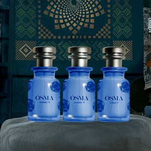 Three blue bottles labeled 'Osmia' on a gray surface with a decorative background.