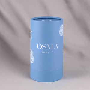 Blue cylindrical container with 'OSMA' branding on a light gray background