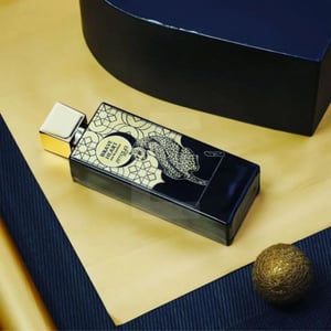 Perfume bottle with decorative packaging on a textured surface